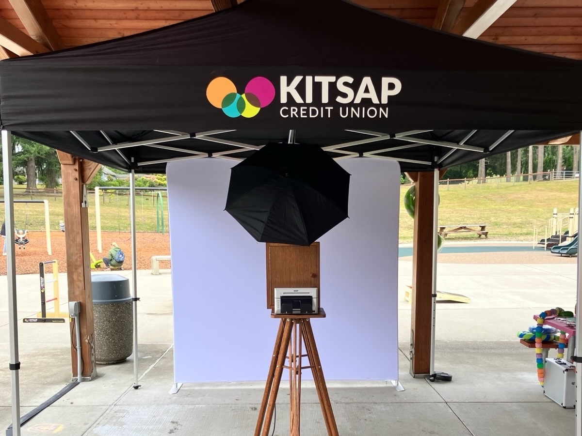 The booth set up under a branded tent at an outdoor corporate event